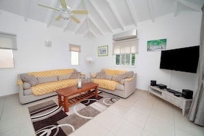 Grand séjour ouvert sur la terrasse, salon climatisé, ventilateur au plafond, HD-TV, Dish Network.