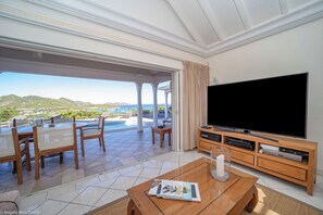 Grand séjour climatisé et ouvert sur la terrasse, HD-TV, Dish Network, ventilateurs.