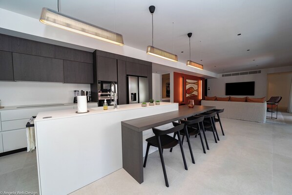 Fully equipped kitchen, oven, microwave, refrigerator with ice maker, dishwasher, blender, toaster, filter coffee maker and Nespresso machine, kettle, stove, bar with stools.