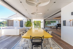Grande table à manger pour 14 personnes sur la terrasse couverte. 