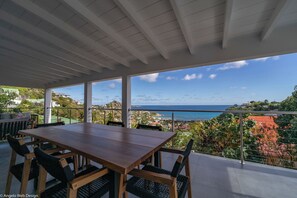 Modern kitchen equipped with a breakfast bar, electric oven, gas stove, fridge and freezer with ice maker, dishwasher, microwave, toaster, Nespresso coffee machine, blender, hood, electric kettle. Dining table for 6 people on the covered terrace. 