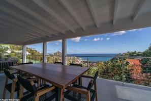 Modern kitchen equipped with a breakfast bar, electric oven, gas stove, fridge and freezer with ice maker, dishwasher, microwave, toaster, Nespresso coffee machine, blender, hood, electric kettle. Dining table for 6 people on the covered terrace.