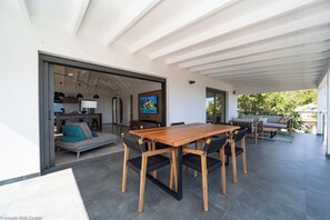 Modern kitchen equipped with a breakfast bar, electric oven, gas stove, fridge and freezer with ice maker, dishwasher, microwave, toaster, Nespresso coffee machine, blender, hood, electric kettle. Dining table for 6 people on the covered terrace. 