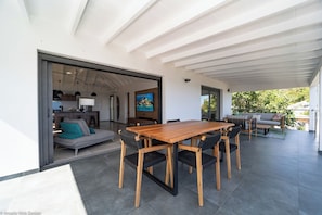 Modern kitchen equipped with a breakfast bar, electric oven, gas stove, fridge and freezer with ice maker, dishwasher, microwave, toaster, Nespresso coffee machine, blender, hood, electric kettle. Dining table for 6 people on the covered terrace.