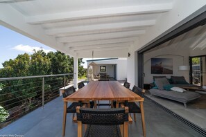 Modern kitchen equipped with a breakfast bar, electric oven, gas stove, fridge and freezer with ice maker, dishwasher, microwave, toaster, Nespresso coffee machine, blender, hood, electric kettle. Dining table for 6 people on the covered terrace.
