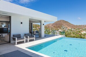 Large heated lap pool on the main level with steps. Expansive terrace, confortable ratten seatings. 