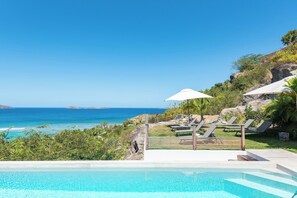 Large heated lap pool on the main level with steps. Expansive terrace, confortable ratten seatings. 