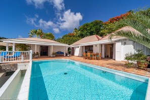 Expansive terrace with teack lounge chairs, surrounding a beautiful pool. Outdoor shower. 