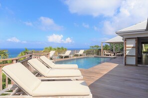 Beautiful pool with steps, expansive terrace with sun loungers. 