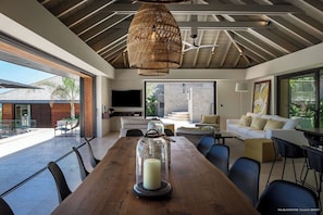 Indoor dining area with dining table for twelve people. Outdoor dining area near the pool, sofas and a rectangular wooden table covered with a parasol. Breathtaking views.