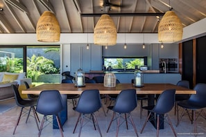 Indoor dining area with dining table for twelve people. Outdoor dining area near the pool, sofas and a rectangular wooden table covered with a parasol. Breathtaking views.
