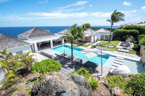 Située dans la villa principale. Grande piscine chauffée entourée de grandes terrasses avec chaises longues, barbecue à gaz. 