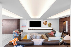 Pièce située au niveau inférieur par un escalier. Salle climatisée, grand salon avec rétroprojecteur et HD-TV, Dish Network, lecteur DVD, station d'accueil iPod, Apple TV. Vue sur l'océan. 