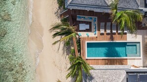Superb sunny terrace with sun loungers that surrounds the heated swimming pool. Direct access on the beach. 