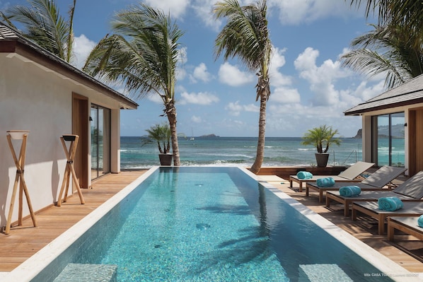 Superb sunny terrace with sun loungers that surrounds the heated swimming pool. Direct access on the beach.