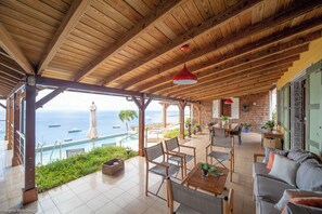 Coin lounge sur la terrasse couverte, face à la vue panoramique.