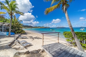 A spacious white sandy ground is perfect for a soccer game or to play bocce. Private beach area with lounge chairs, feet in the water. Kayaks, paddle boards, surfboards and snorkeling gears are also at disposal. 