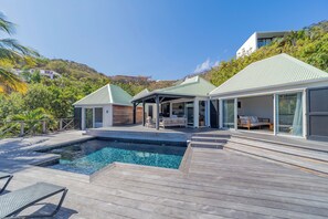 Belle piscine entourée par une grande terrasse, chaises longues. Barbecue à gaz.