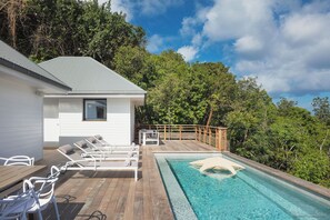 Belle piscine face à la vue panoramique, grande terrasse avec chaises longues et coins lounge. Barbecue à gaz.