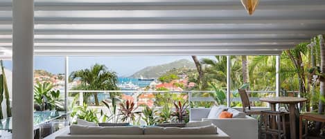 Coin lounge avec sofas, face à la vue panoramique sur le port de Gustavia. 