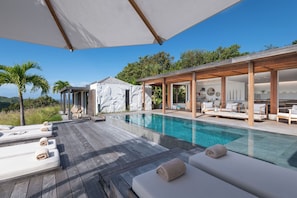Large infinity pool (8m x 3,5m) with wading area and stairs, surrounded by a spacious wood deck with 6 lounge chairs. Ocean & sunset view.