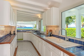 Open-air fully equipped kitchen. Electric oven, gas stove, microwave, refrigerator, mixer, freezer, dishwasher, Nespresso machine, blender, kettle, toaster, breakfast bar. Indoor dining table and dining area on the covered terrace.