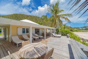Hammock and wood lounge chairs. Outside shower. Direct access to the beach.