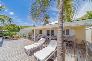 Hammock and wood lounge chairs. Outside shower. Direct access to the beach.