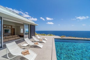 Beautiful heated pool surrounded by a sunny deck with deckchairs, facing the breathtaking panorama. 