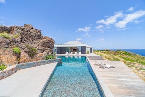 Beautiful heated pool surrounded by a sunny deck with deckchairs, facing the breathtaking panorama. 