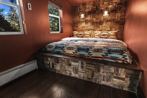 The bedroom features a plush custom-built King-sized bed, with patio doors leading to your small private deck.