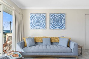 An open-plan living area includes a sofa and a TV where guests can settle in with a movie