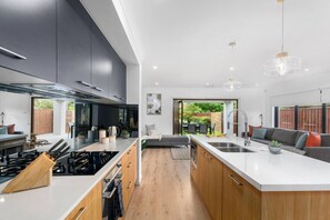 The sleek kitchen is designed around a centrepiece island bench and kitted with top quality appliances and utensils.