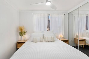 The main bedroom comes fitted with a king-sized bed, side tables and built-in wardrobe.
