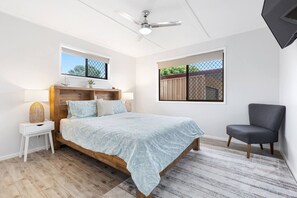 The spacious master bedroom offers a queen-size bed along with bedside tables and lamps. 