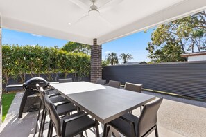 The patio has an outdoor table for eight, with a barbeque. It sits under shade with outdoor lighting and ceiling fan so you can dine any time of day in any weather. 