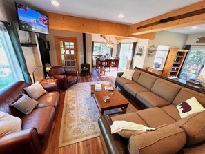 Quintessential cabin living room with tons of seating and beautiful pine views