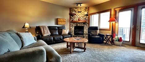 Spacious living room with gas fire place with door to deck and hot tub