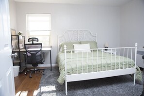 Bedroom with queen size bed and desk.