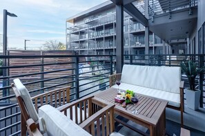 Private Balcony offering outdoor lounging and dining with a pool and courtyard view.