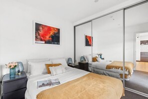 Enjoy ultimate style and comfort with views out to the balcony from this Queen bedroom with floor to ceiling mirror wardrobe illuminating the room with natural light.