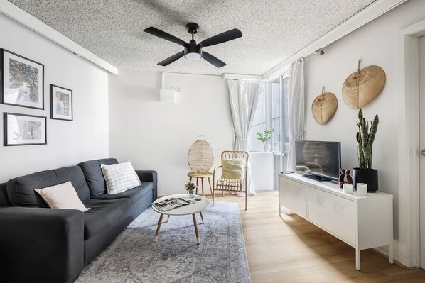Lounge around in the spacious living area complete with a cosy sofa, rattan reading chair and a flat-screen TV. A ceiling fan keeps things comfortable. 