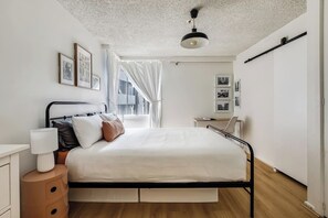 The charming, minimal bedroom is complete with a plush queen bed, storage for your belongings and a large window.

