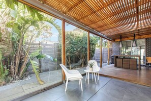 The undercover patio offers seating to enjoy your morning coffee and features a high dining table and BBQ.