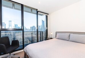 A master bedroom is furnished with a queen bed, black-out blinds and thoughtful decor, and has spectacular views of the CBD