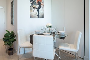  Enjoy a home cooked meal or work from home at the four-person glass dining table with plush leather seats