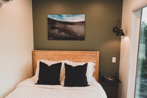 Bedroom: Queen bed with AC, TV, and outdoor view
