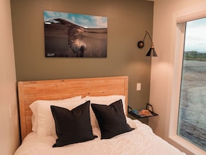 Bedroom: Queen bed with AC, TV, and outdoor view