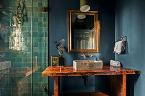 The spa-inspired bathroom features deep green and blue colors inspired by the night sky. The rustic sink and textures remind you that you're in the mountains and have escaped your everyday life.