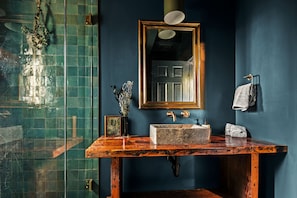 The spa-inspired bathroom features deep green and blue colors inspired by the night sky. The rustic sink and textures remind you that you're in the mountains and have escaped your everyday life.